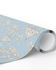 A roll of wrapping paper featuring a whimsical pattern of hot air balloons, carousel horses, and a rabbit on a light blue background, shown on a clean white studio background.