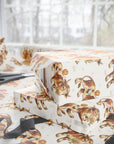 Gift boxes wrapped in vintage baby paper with bull and baby pattern on a light surface.