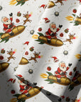 Ivory wrapping paper with a festive Christmas pattern featuring Santa Claus riding gold rockets, accompanied by reindeer, gifts, and snow globes, shown with soft folds and shadows.