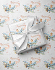 Powder blue baby shower wrapping paper with vintage biplanes, little girl pilots, blush pink banners, white clouds, and small roses.
