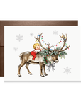 Vintage-style baby in red pajamas hugging a reindeer with antlers strung in multicolor Christmas lights and a pine wreath, baby's first Christmas card