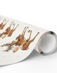 A roll of Christmas baby shower wrapping paper featuring a baby atop a festive reindeer on an ivory background.