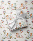 Baby shower wrapping paper featuring babies climbing elegant swans with floral hats in a soft pink and blue storybook design.