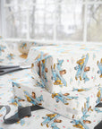 Gift-wrapped boxes and wrapping paper with a repeating airplane-and-child pattern, styled on a table near scissors and a window.