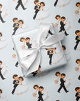 Gift with a satin ribbon resting on a repeating pattern of vintage-style dancing newlywed bride and groom on pale blue wrapping paper