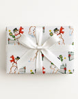 christmas gift wrapped in white paper with a repeating illustration that features different snowmen playing pickleball in the snow.