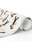 A roll of wedding wrapping paper with a repeating pattern of vintage illustrated bride and groom couples dancing joyfully.