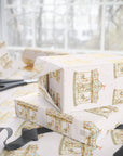 Gift boxes wrapped in light pink carousel wrapping paper.
