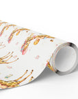 Roll of giraffe baby boy wrapping paper with a repeating pattern of baby boys riding giraffes in floral bonnets, baby bottles and tiny roses