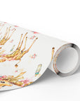 Roll of giraffe baby girl wrapping paper with a repeating pattern of baby girls riding giraffes in floral bonnets, pink bows, baby bottles and tiny roses
