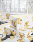 Gift boxes wrapped in paper featuring a little girl flying a pale yellow biplane over a delicate aviation navigation map on an ivory background, displayed with an open roll of matching wrapping paper, dark ribbon, and scissors.