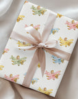 Gift box wrapped in paper featuring baby girls flying pastel airplanes tied with a satin ribbon.