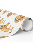 A roll of baby shower wrapping paper featuring a repeating vintage-style print of golden lions with floral crowns and darling babies on an ivory background.