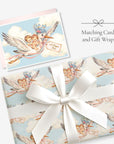 Twin baby boy and girl stork card with matching stork gift wrap tied with a white satin bow, labeled Matching Card and Gift Wrap
