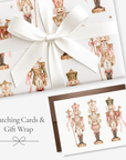 Pink nutcracker Christmas card with matching vintage-style nutcracker gift wrap tied with a white satin bow