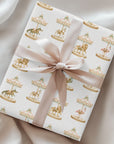Wrapped gift featuring Palm Beach Carousel Wrapping Paper with carousel animals beneath pastel pink and mint canopies tied with a satin ribbon.