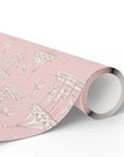 A roll of pink wrapping paper featuring a delicate vintage illustration pattern of carousel horses, shown partially unrolled on a clean white background.