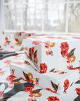 Stacked Christmas gifts wrapped in vintage-style patriotic angel wrapping paper on a wrapping table with scissors and black ribbon