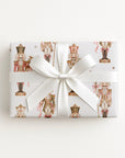 Gift wrapped in vintage-style pink and cream nutcracker soldier Christmas wrapping paper with a white satin bow, pink nutcracker gift wrap
