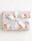 Small gift wrapped in polar bear baby girl wrapping paper with a white bow, winter baby shower gift