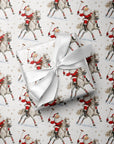 A wrapped gift box with a white satin ribbon sits on top of Christmas-themed wrapping paper featuring a repeating pattern of Santa Claus playing polo, horseback with a mallet in hand.
