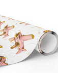 A roll of wrapping paper featuring a repeating pattern of airplanes in pink with gold accents on an ivory background.