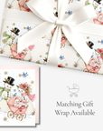 Vintage-style snowman baby girl Christmas card with matching pink baby carriage snowman gift wrap, tied with white satin ribbon