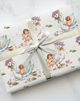 Gift wrapped in vintage-style baby and swan wrapping paper on a marble surface.