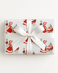 Gift wrapped in vintage-style triplets first Christmas wrapping paper with a woman in a red coat trimmed with white fur pushing a pram with three sleepy babies, tied with a white satin ribbon bow, Winter Wonderland triplets baby shower gift wrap