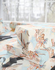 Stacked gifts wrapped in twin boys stork wrapping paper beside a sunny window