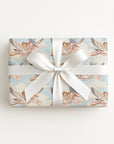 Twin boys stork wrapping paper on a gift tied with a white satin bow