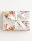 Twin girl airplane wrapping paper featuring two little aviators flying in a pastel pink vintage biplane.