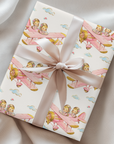 Wrapped gift featuring twin girls flying a pink biplane tied with a blush satin ribbon.