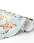 Roll of vintage-style twin baby shower wrapping paper with storks carrying a baby boy and girl on soft blue clouds