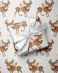 Christmas and winter baby shower wrapping paper roll with repeating baby and reindeer illustration.