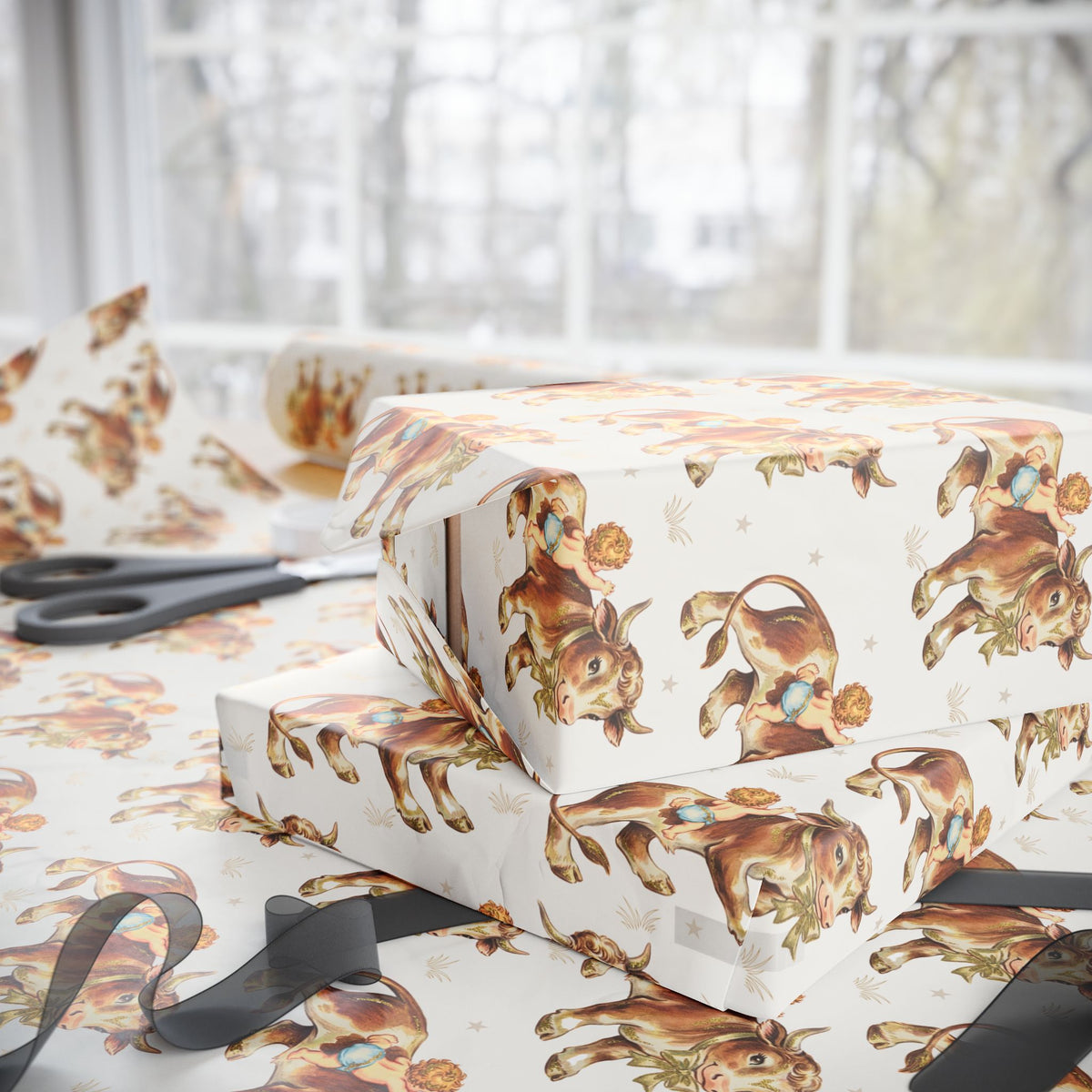 Gift boxes wrapped in vintage baby paper with bull and baby pattern on a light surface.