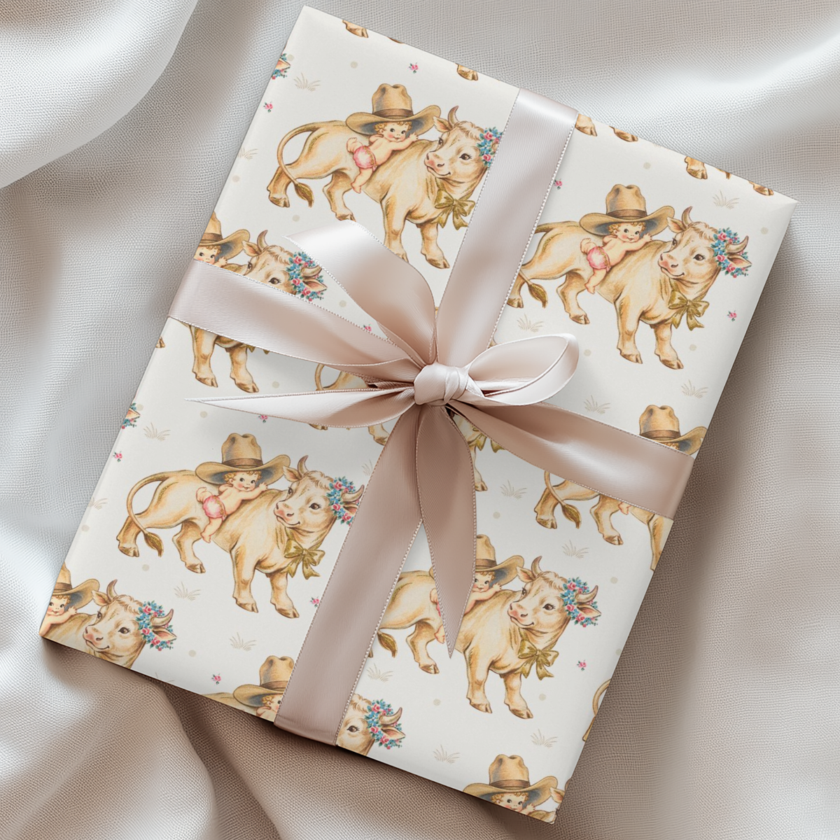 Gift wrapped in paper with darling cow and baby illustrations and tied in a  pink ribbon.