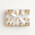 Gift box with a sweet baby and cow pattern with a white ribbon on a light background.