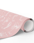 A roll of light pink wrapping paper with a white carousel animal pattern of whimsical illustrations, shown partially unrolled on a clean white background.