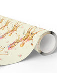 A roll of wrapping paper featuring a whimsical watercolor print of giraffes and babies on a butter yellow background,