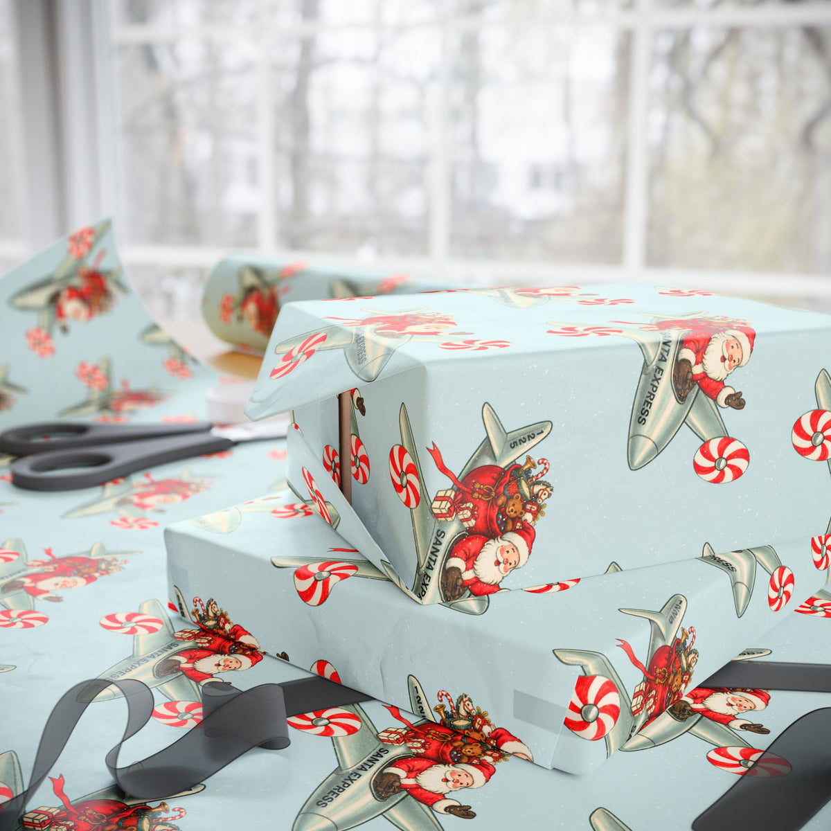 Light blue Christmas airplane wrapping paper featuring Santa Claus as a pilot, shown wrapped around gift boxes on a table near a window. 