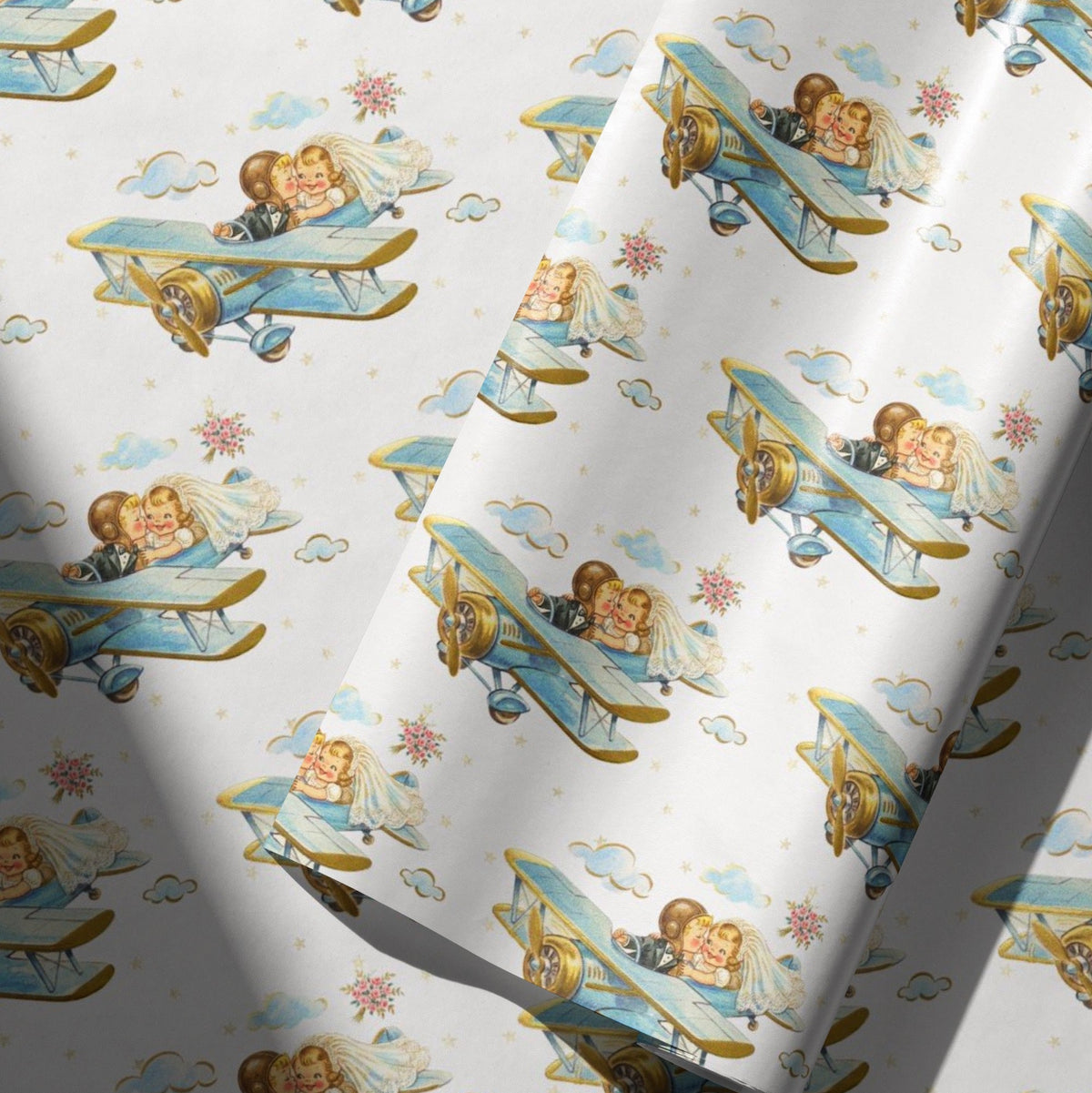 Vintage-style wedding wrapping paper with a bride and groom kissing in a blue biplane, surrounded by clouds, tiny stars and pink flower bouquets.