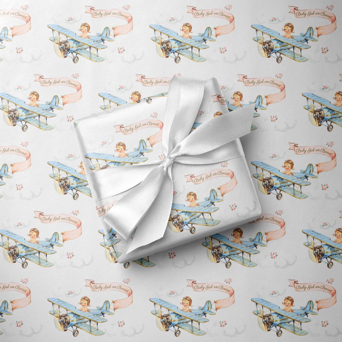 Powder blue baby shower wrapping paper with vintage biplanes, little girl pilots, blush pink banners, white clouds, and small roses.