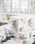 Wrapped gifts in Baby Girl on Board wrapping paper featuring a little girl pilot, blue biplanes, pink banners, clouds, and roses.