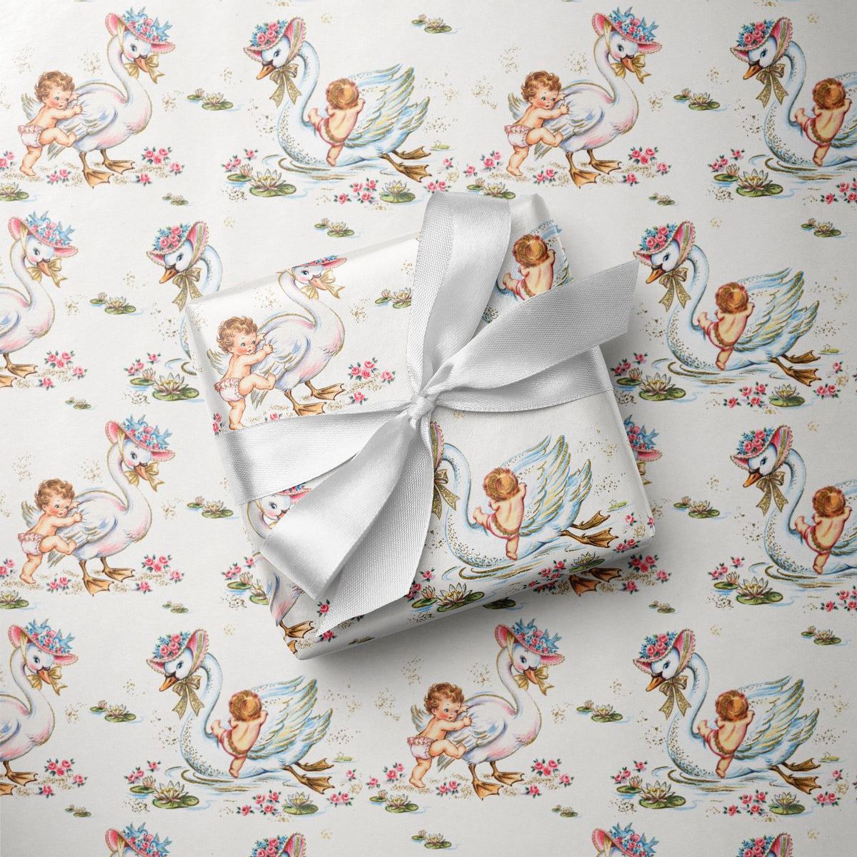 Baby shower wrapping paper featuring babies climbing elegant swans with floral hats in a soft pink and blue storybook design.