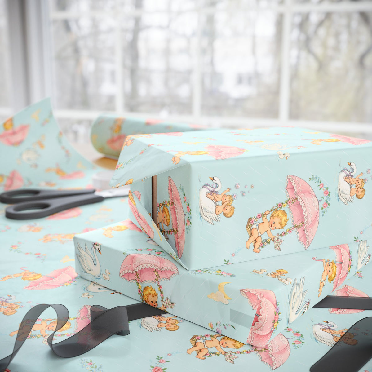 Pastel wrapping paper with a whimsical babies on floral swings pattern, shown wrapped around gift boxes on a table with scissors and ribbon near a bright window.