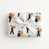 Gift wrapped in vintage bride and groom wrapping paper featuring a playful newlywed couple on pale blue, finished with a white satin bow.