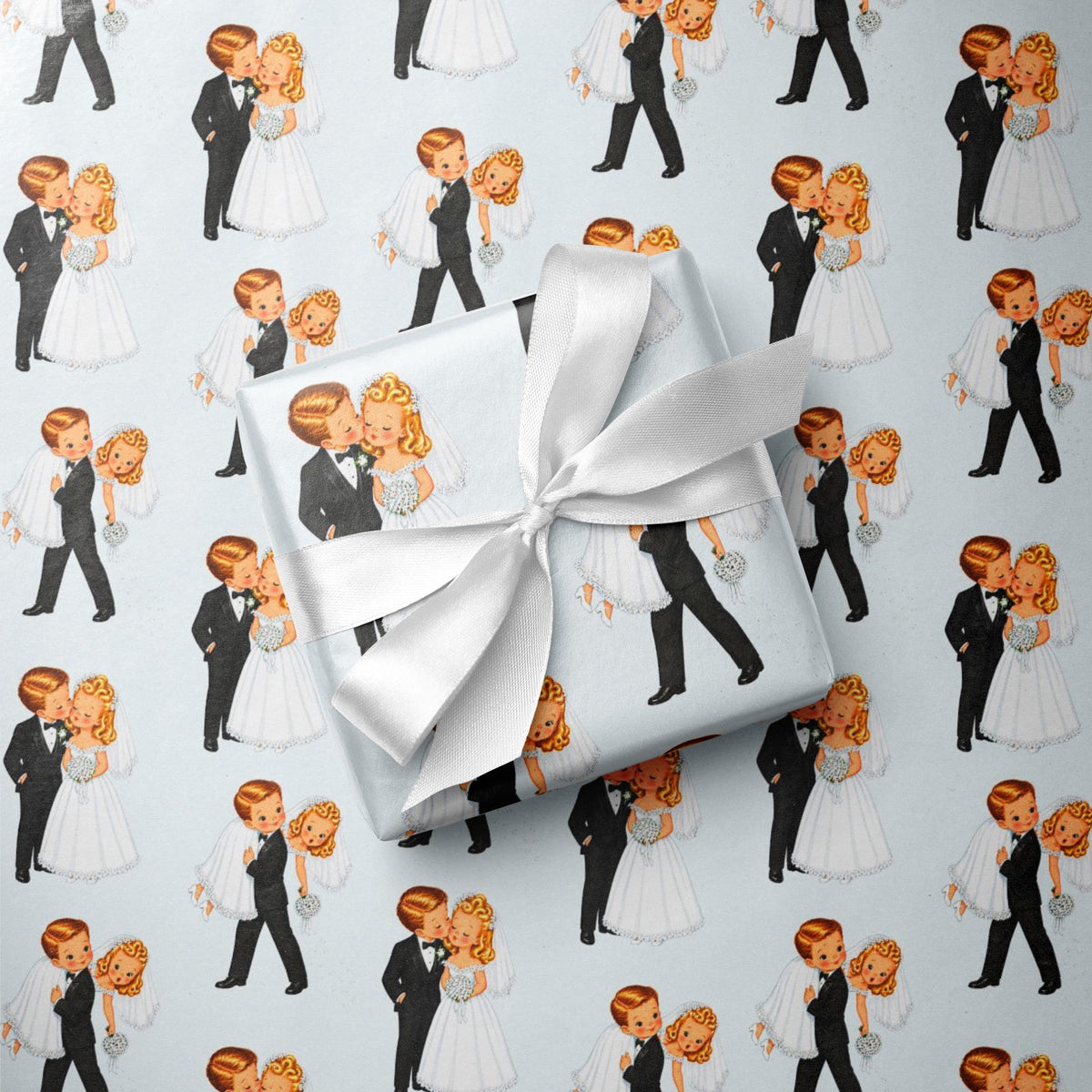 Vintage bride and groom wrapping paper featuring a playful newlywed couple kissing on a pale blue background.
