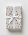 Gift wrapped in minimalist wedding cake wrapping paper with tiered cakes and pink roses, tied with a white satin ribbon and bow