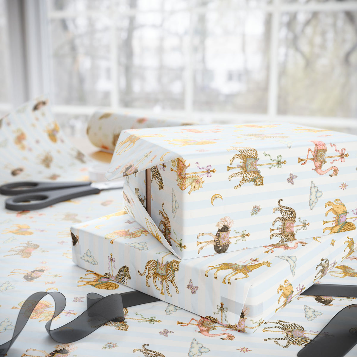 Stack of gifts wrapped in Carousel Menagerie wrapping paper featuring whimsical carousel animals on blue stripes, shown with matching gift wrap and ribbon.